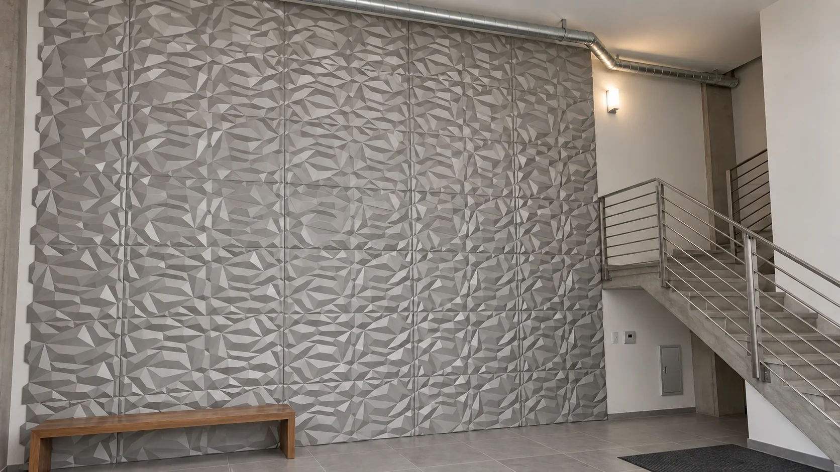 Concept image: a double-height lobby with a light 3D panel wall, a metal stair and a bench.