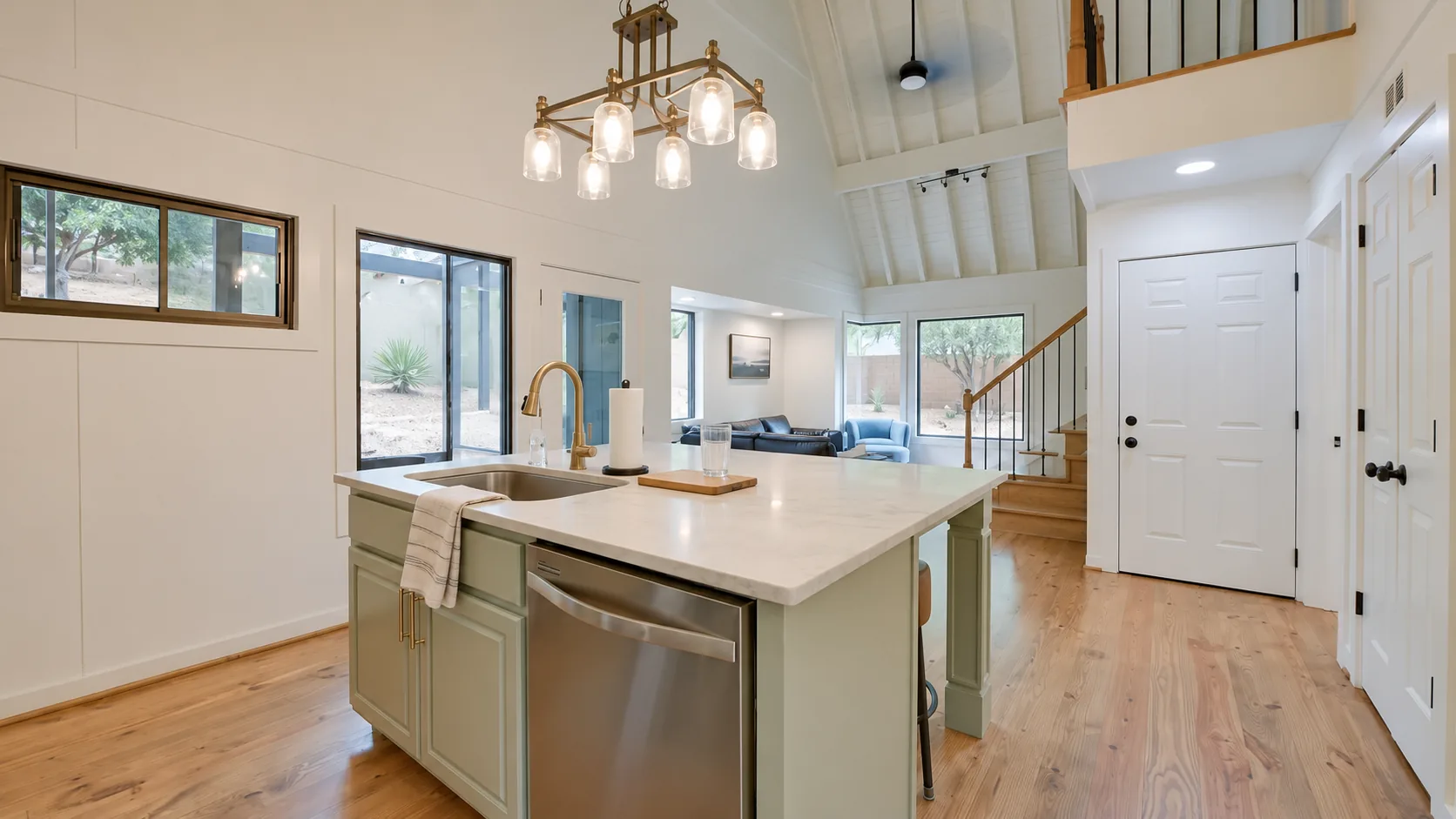 Concept image: a remodeled kitchen with a sage island, white cabinets and wood floors.