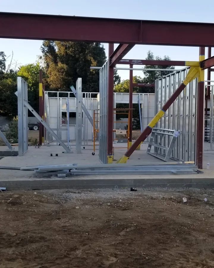 Site photo: a steel frame and metal studs on a slab.
